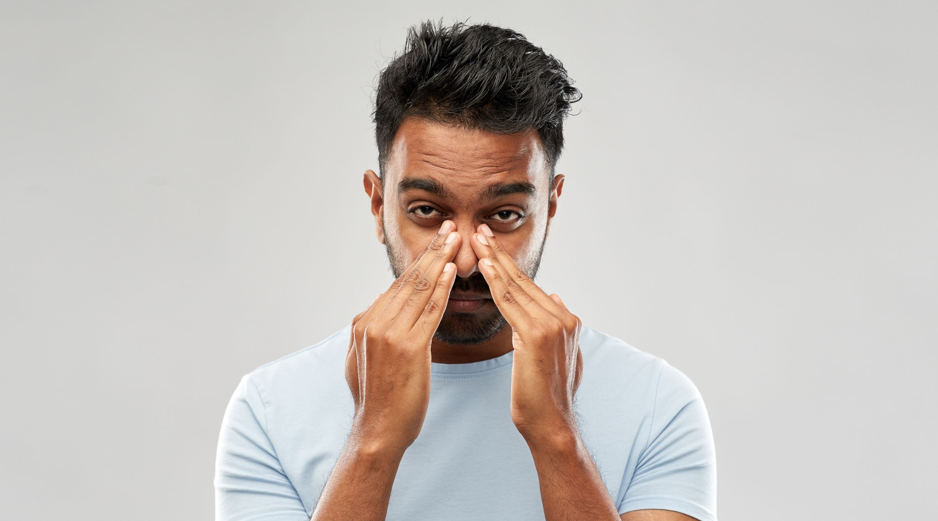 Woman applying nasal strip to unblock her nose and relieve congestion