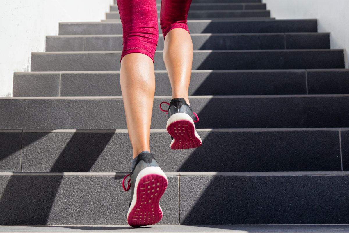 Image of a woman's legs in pink leggings and pink running shoes running up a flight of stairs, highlighting the benefits of using Nozey's Active Strips for cardio and running. This image emphasizes the importance of being able to breathe easily during physical activity and the benefits of using Active Strips to support nasal breathing while running or engaging in cardio workouts.